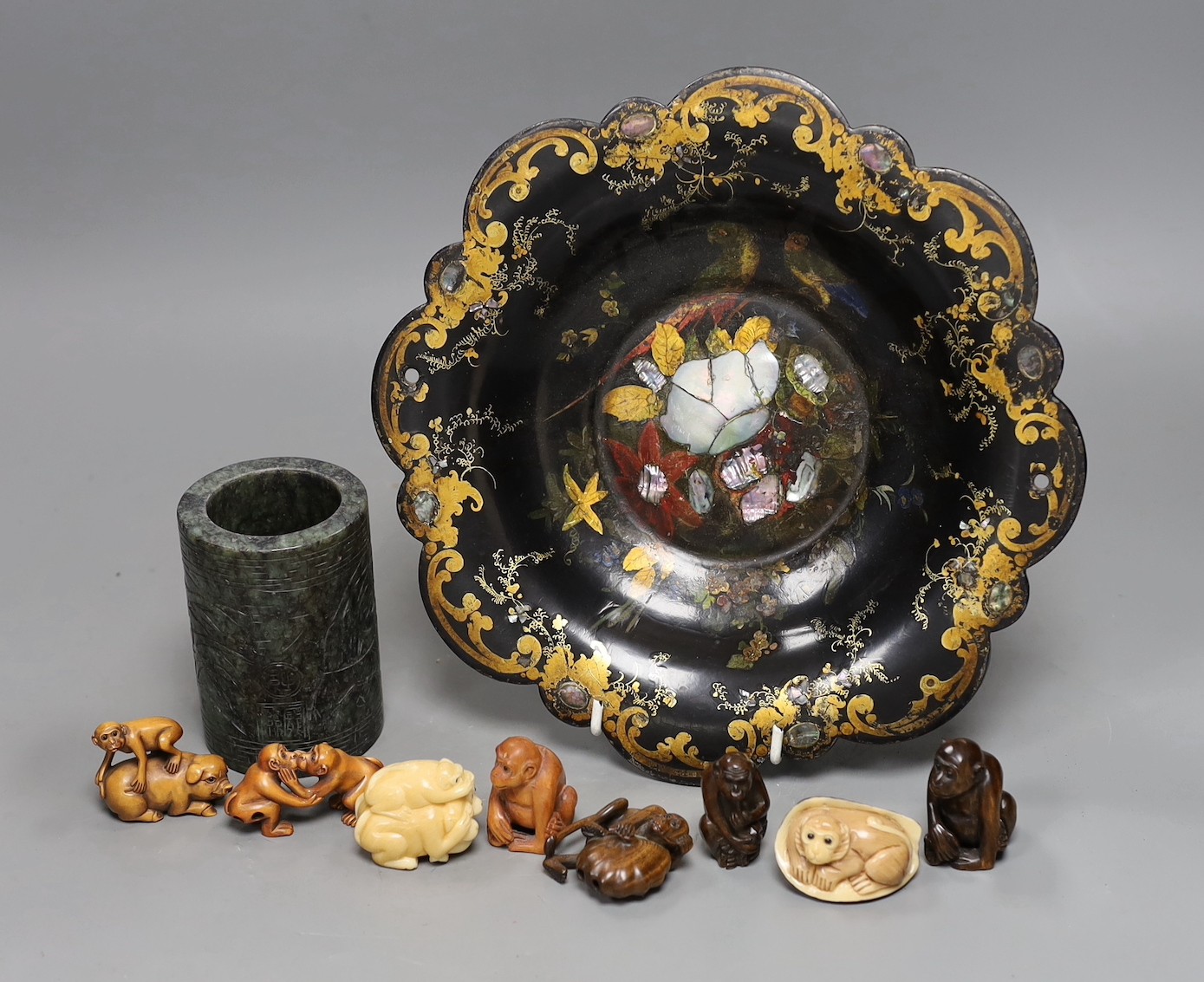 A Chinese soapstone brush pot and a group of netsuke and a papier mache dish, 26cms diameter